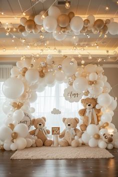 there are balloons and teddy bears on the floor in front of this stage set up for a baby's first birthday party