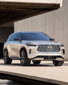 a white suv parked in front of a concrete building next to a body of water