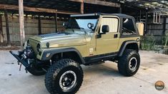a green jeep parked in front of a building