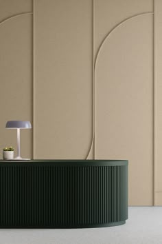 a round table with a lamp on it in front of a wall that has curved panels
