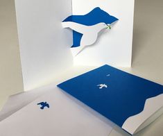 an open card with blue and white paper cut out to look like a plane on it