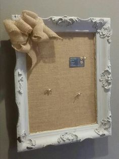 a white frame with a bow hanging on the wall