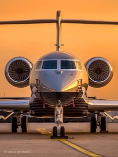 an airplane is parked on the tarmac at sunset with its wheels still in position