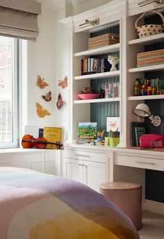 a bedroom with white bookcases and lots of books