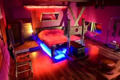 a bedroom with pink walls and wooden floors is lit up by colorful lights from the ceiling