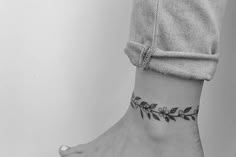 a black and white photo of a woman's ankle tattoo