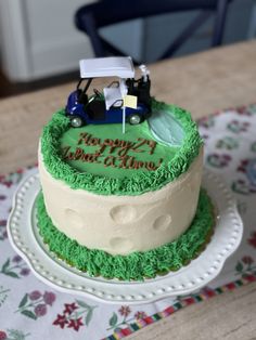 a green and white cake with a car on top