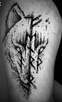 the back of a man's shoulder with black ink on it and an abstract wolf head