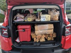 the back end of a red car filled with food