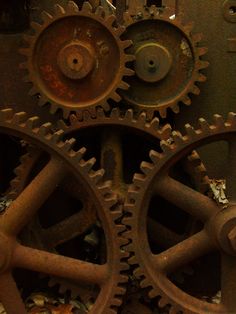 an old clock with two gears attached to it's sides and rusted parts