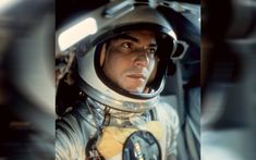 a man in an astronaut suit is looking at the camera