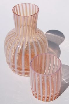 two glass vases sitting next to each other on a table