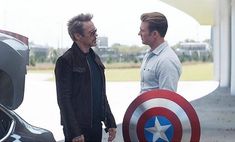two men standing next to each other holding a shield