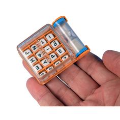 an orange and white toy cell phone with keys in it's case on a person's hand