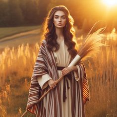 a woman in a brown and white striped robe holding a stick with wheat stalks on it
