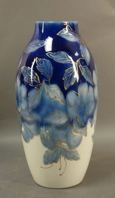 a blue and white vase with flowers painted on it