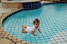 a baby sitting on the edge of a swimming pool