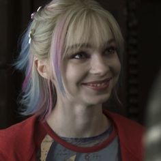 a woman with blonde hair and blue eyes smiles at the camera while standing in front of a mirror