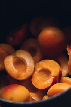some peaches are sitting in a bowl on the table and ready to be eaten