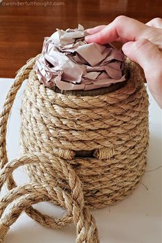 a hand holding a rope wrapped in brown paper