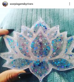 a person is holding a plastic object with glitters in the shape of a flower