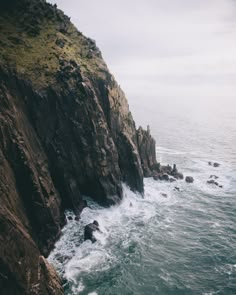 an ocean cliff with waves crashing against the rocks