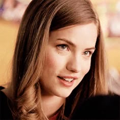 a woman with long hair is smiling for the camera