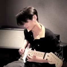 a young man is playing an electric guitar