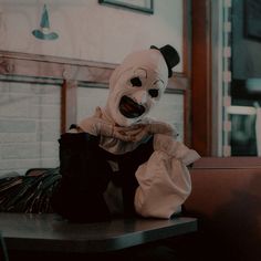 a creepy clown doll sitting on top of a table