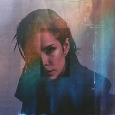 a woman with long hair and piercings standing in front of a blue, green, yellow and pink background