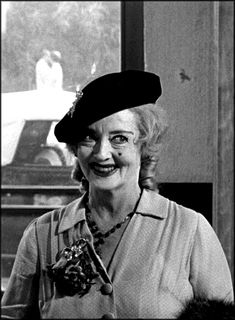 black and white photo of woman in hat smiling