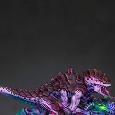 a toy dinosaur with its mouth open and glowing in the dark, sitting on a table