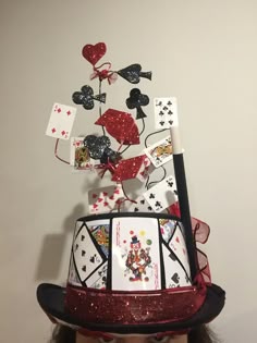 a woman wearing a top hat with cards on it