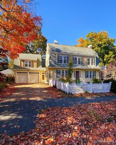 a house with fall leaves on the ground