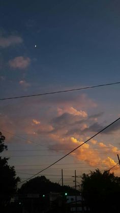 the sun is setting behind some power lines