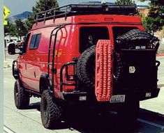 a red truck with some tires on it's back bumpers and tire guards