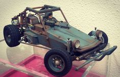 a toy car on display in a glass case with pink flooring and white walls