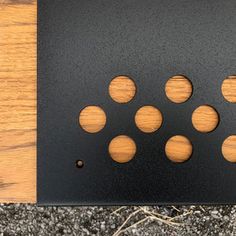 a wooden table topped with black metal and wood circles on top of it's surface