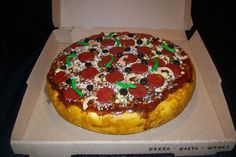 a pizza in a box with pepperoni and olives