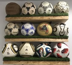 soccer balls are lined up on wooden shelves