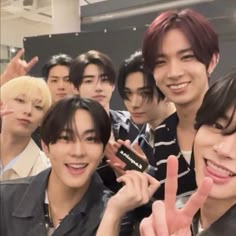 the group of young men are posing together for a photo with their fingers in the air