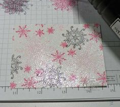 a piece of paper that has snowflakes on it and is next to a ruler