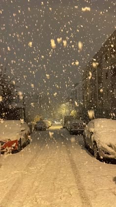 cars parked on the side of a snow covered street