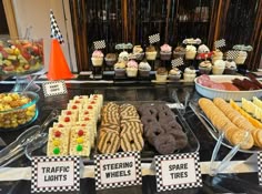 an assortment of desserts on display at a buffet table with checkered paper signs