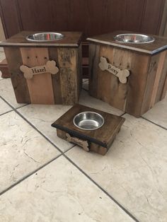 three wooden boxes with dog bowls on them sitting on the floor next to each other