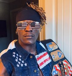 a man wearing sunglasses and an american flag vest