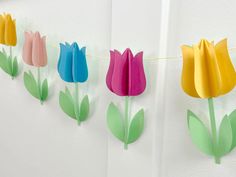 paper tulips are hanging on a string