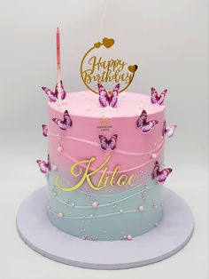 a pink and blue cake with butterflies on it