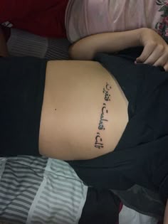 a woman laying down with her back turned to the side and writing on her stomach