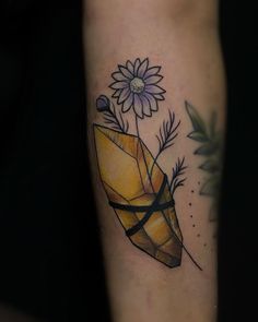 a tattoo on the arm of a person with a flower and an object in it